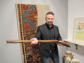 Intendent Rikard Klev med ett av alla de antika vapen som säljs via auktionshuset.